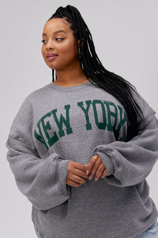 Plus size model wearing New York crewneck sweatshirt in gray.