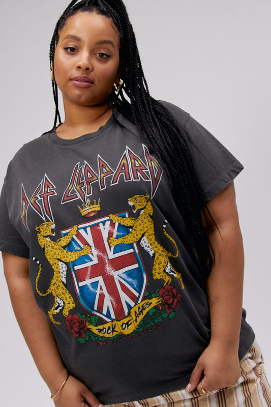 A dark-haired model featuring a black tee stamped with 'Def Leppard' and designed with the UK flag surrounded by two tigers and flowers.