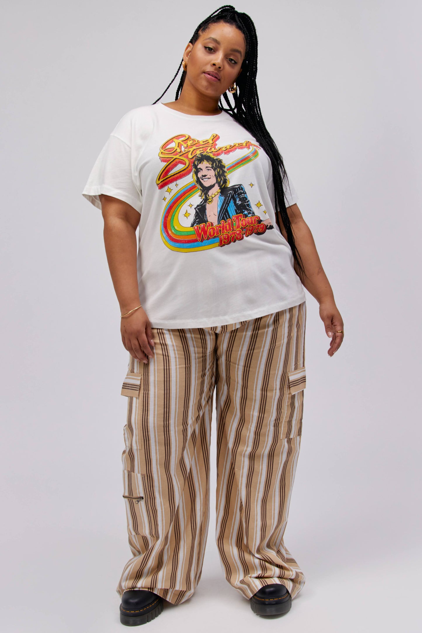 A dark-haired model featuring a white tee stamped with 'Rod Stewart' and a portrait of the artist on top of a rainbow.