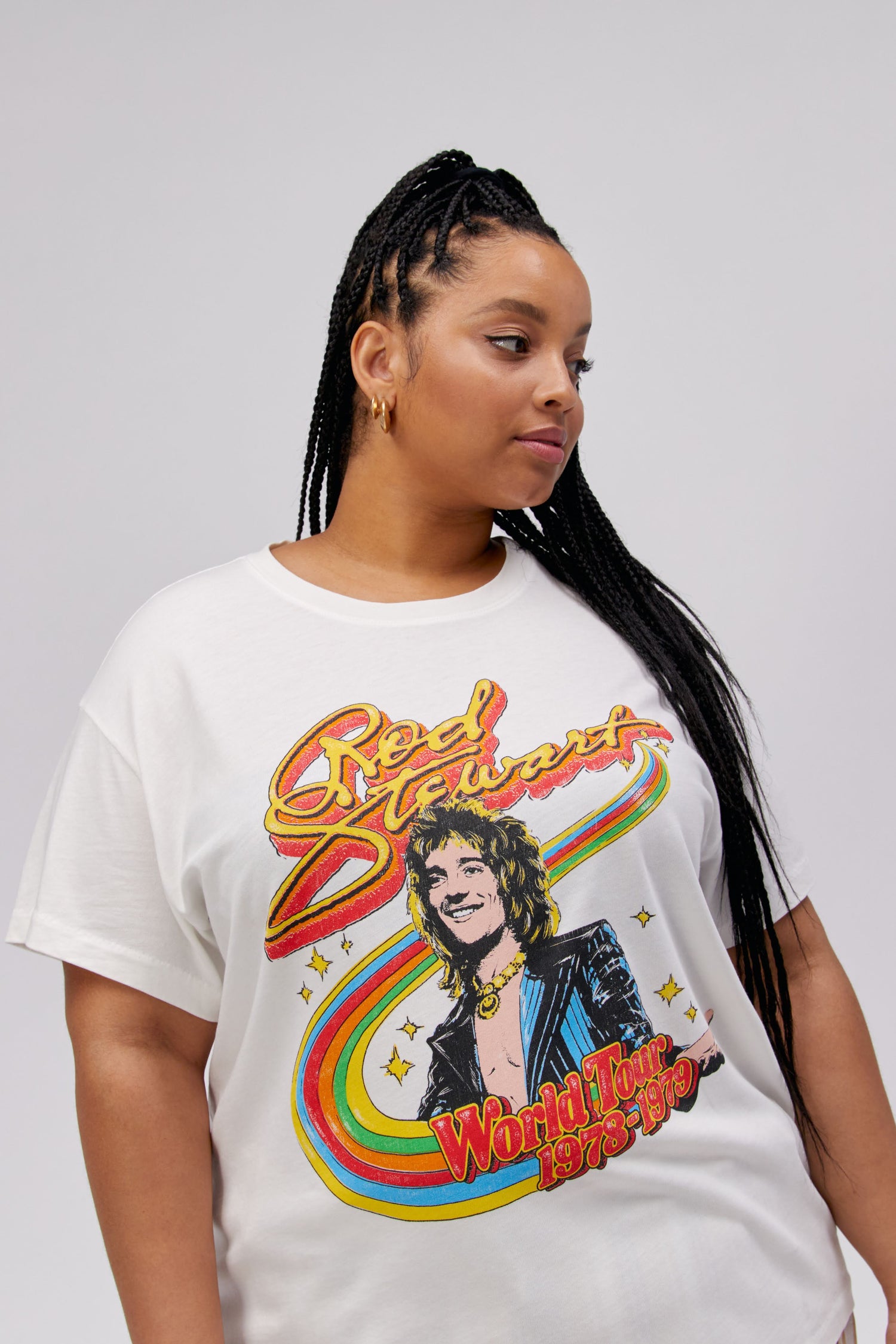 A dark-haired model featuring a white tee stamped with 'Rod Stewart' and a portrait of the artist on top of a rainbow.