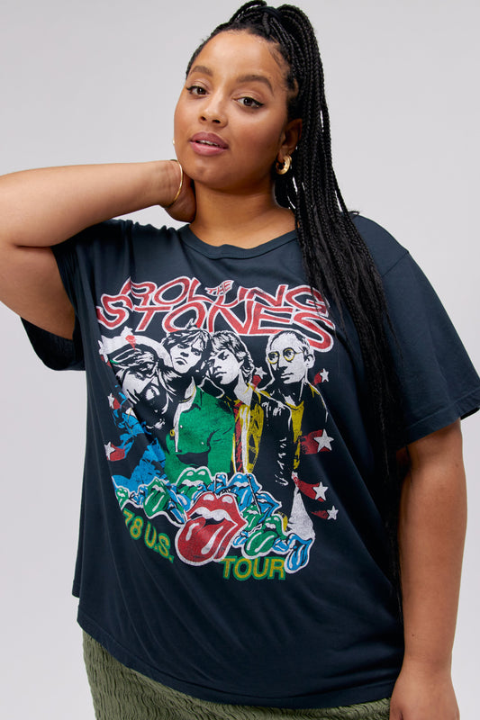 A dark-haired model featuring a vintage black tee stamped with 'The Rolling Stones' and designed with an iconic group photo of the band.