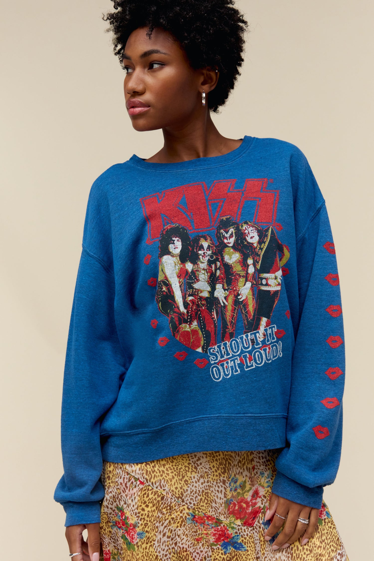 A model featuring a blue oversized crew stamped with "KISS" in red large font and a photo of the band itself.