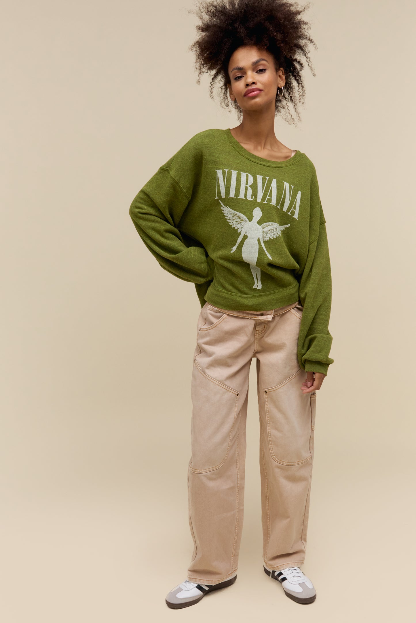 Model wearing a heather green oversized tri-blend fleece sweatshirt with Nirvana 'In Utero' graphics on the front and back