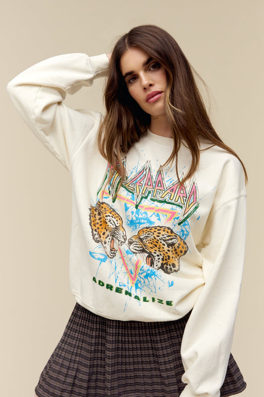 A model featuring a stone vintage bf crew stamped with Def Leppard and a graphic of two leopards facing each other in the middle.