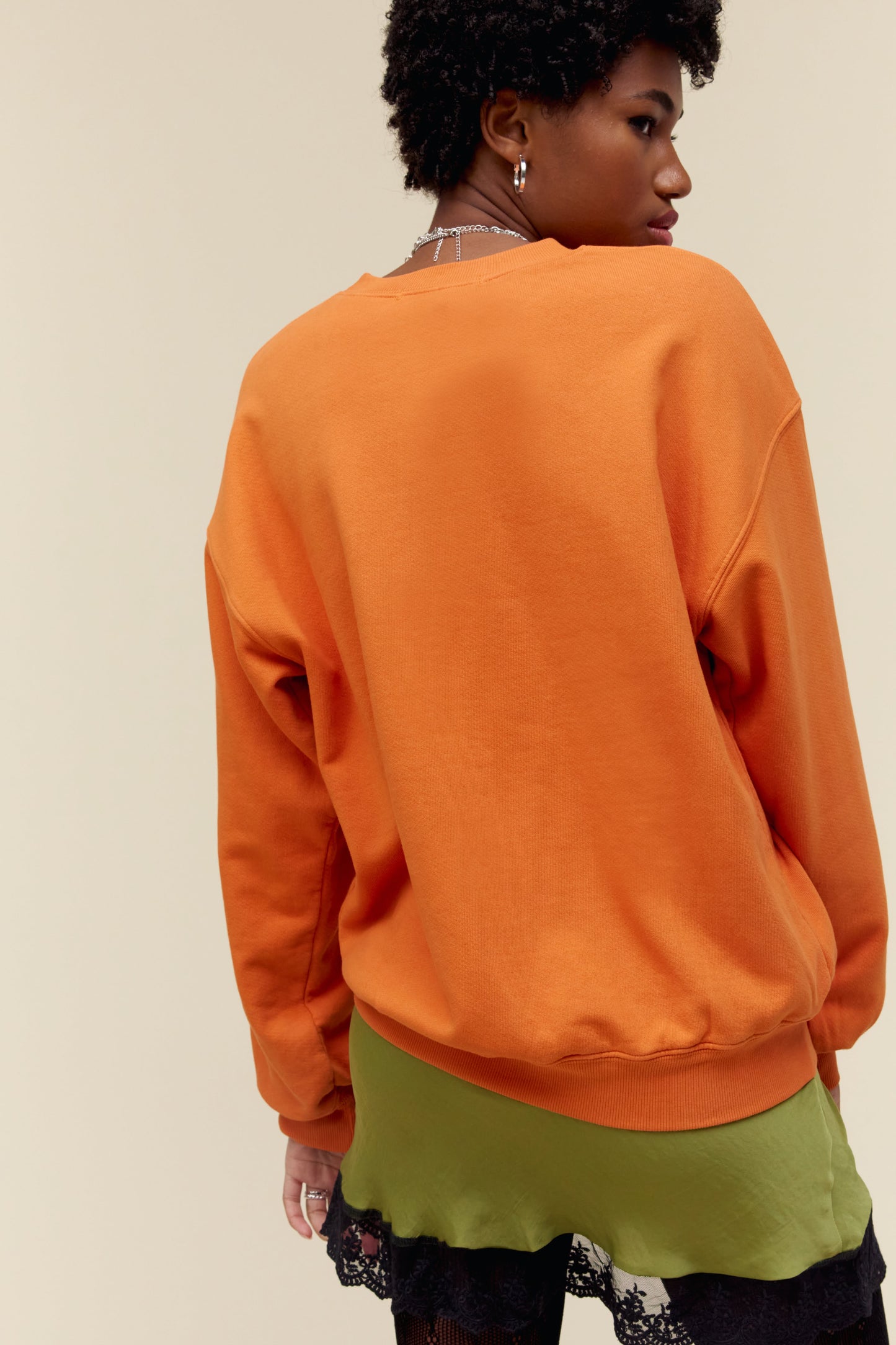 A model featuring a tangerine long sleeve designed with dove artwork - a symbol that’s become synonymous with the crew.