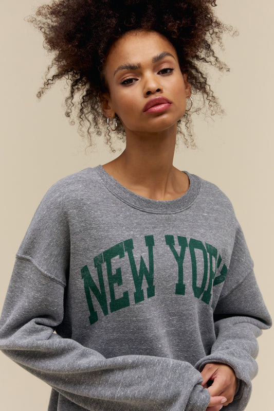 Model wearing a 'New York' collegiate style heather grey sweatshirt in a soft tri-blend fleece