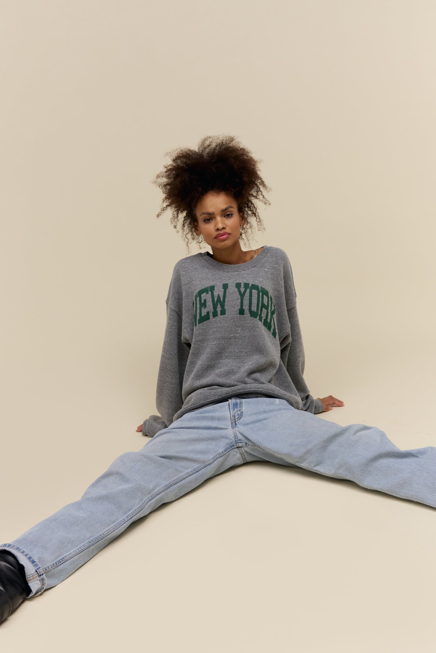 Model wearing a 'New York' collegiate style heather grey sweatshirt in a soft tri-blend fleece