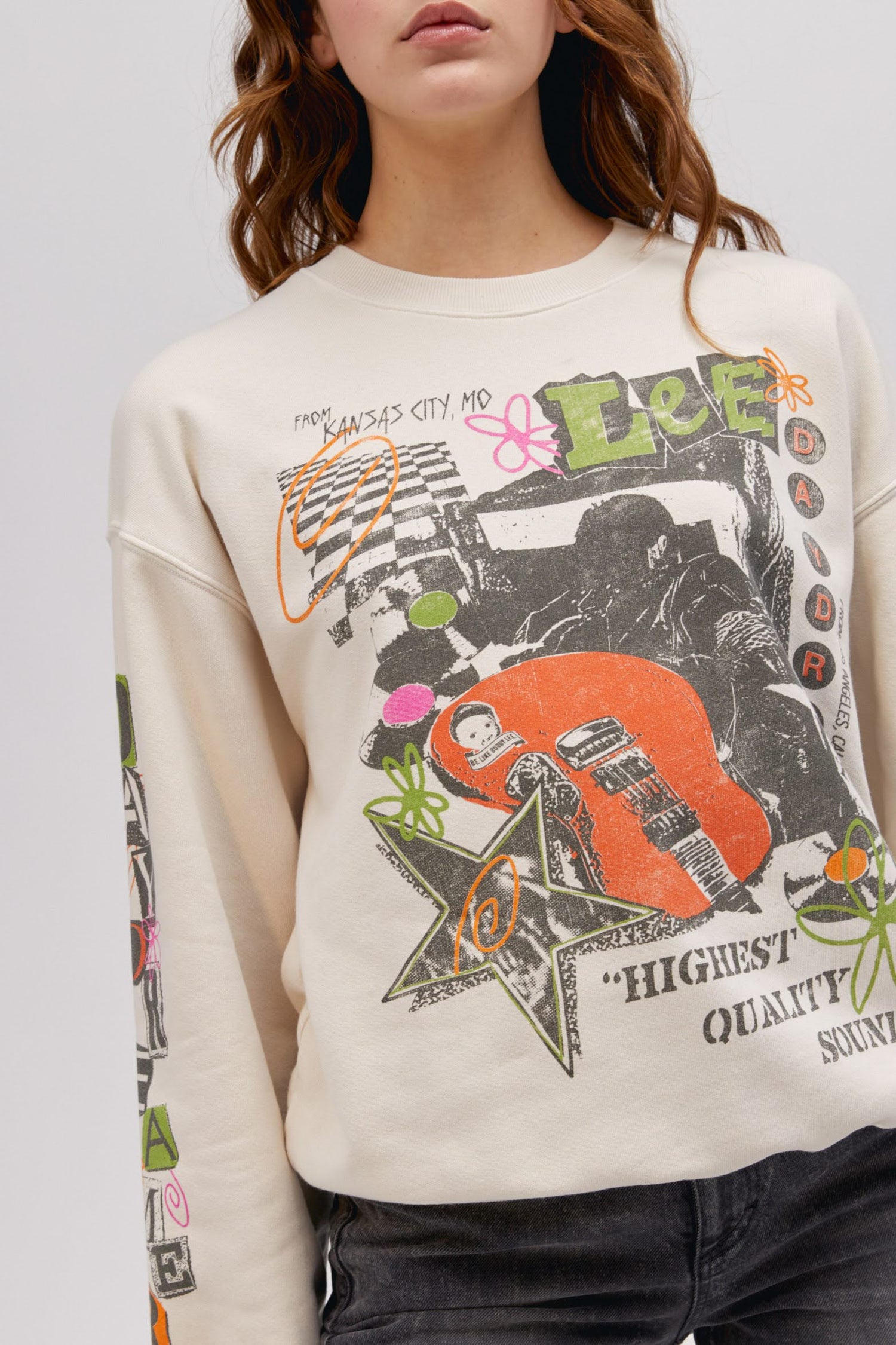 close up detail photo of model wearing off white colored sweatshirt with washed graphics