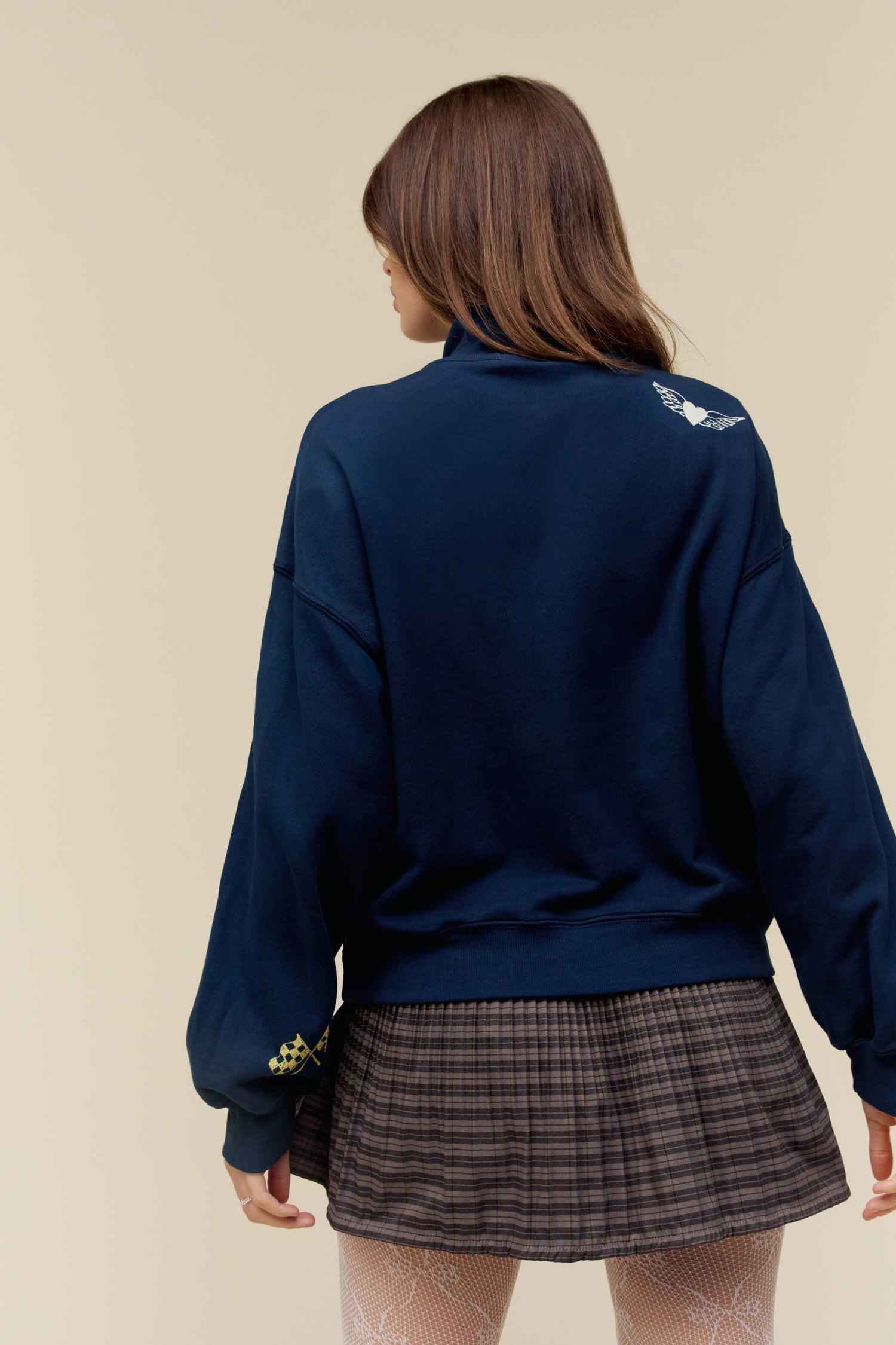A model featuring a surf navy half zip sweatshirt stamped with DYDRMR CO and DDLA.