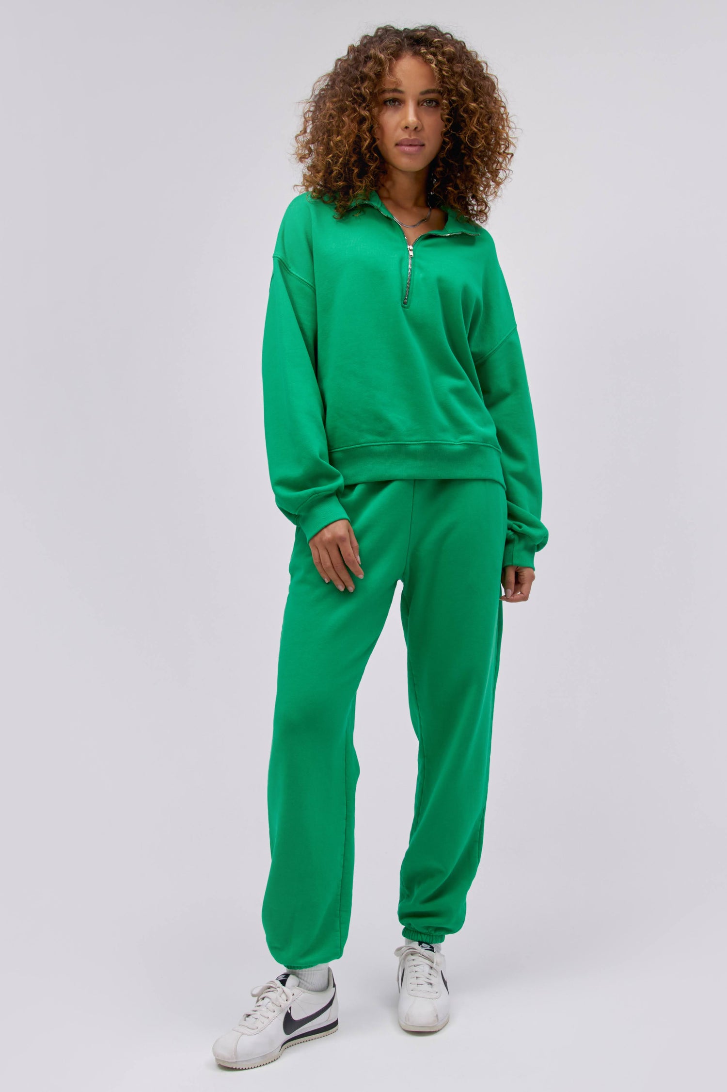 Model wearing a solid half zip sweatshirt in lucky green.