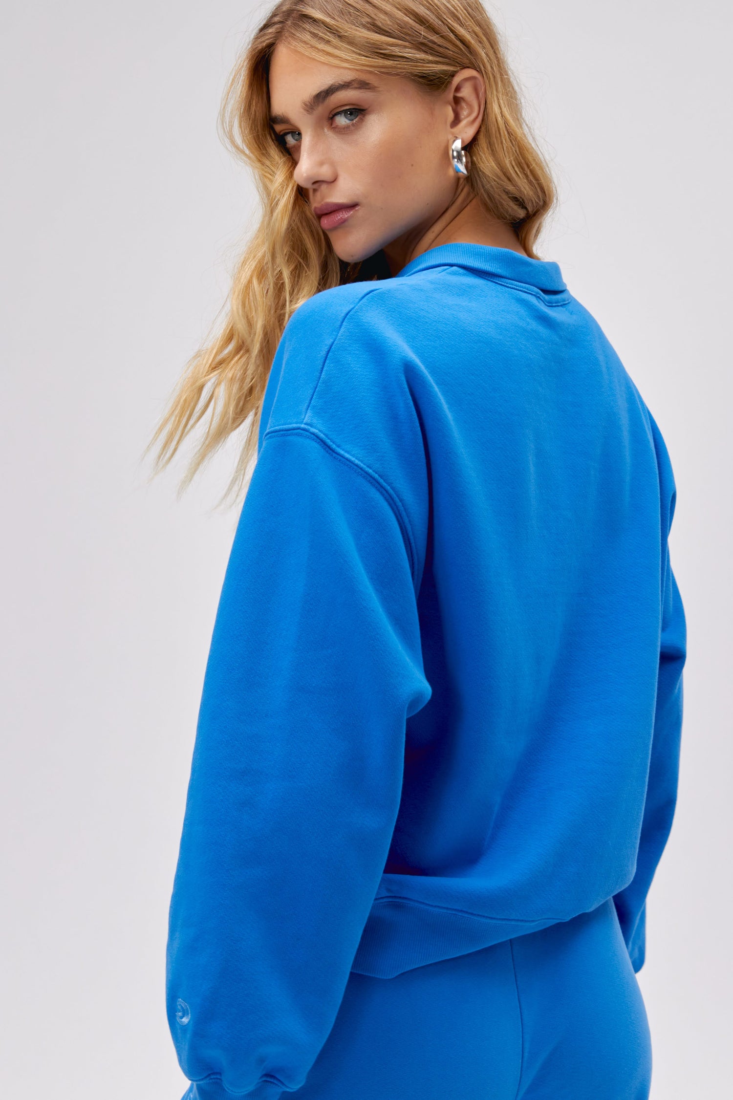 Model wearing a solid half zip sweatshirt in washed cobalt.