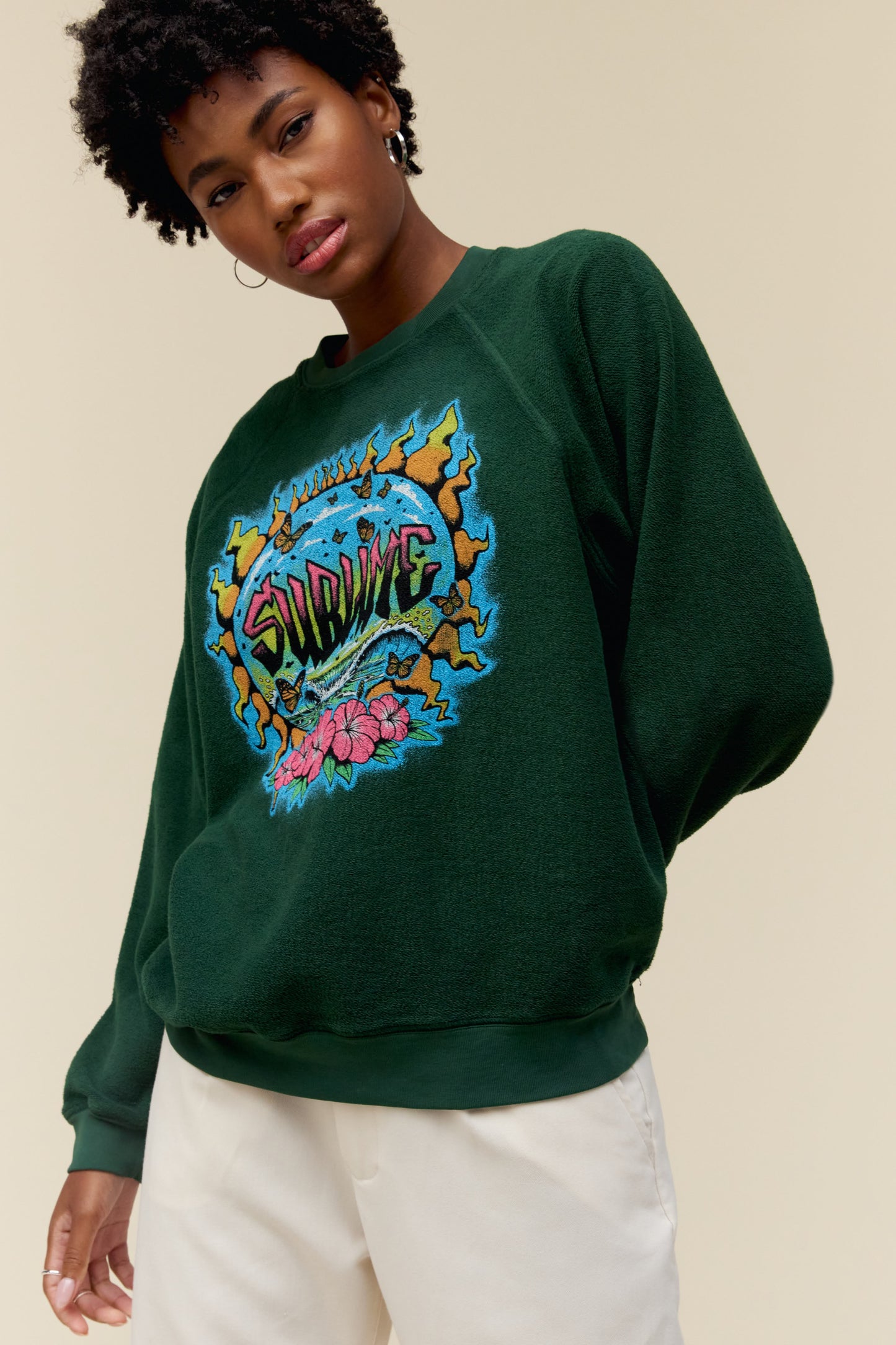 Model wearing a Sublime graphic sweatshirt in vintage green with a reverse fleece construction