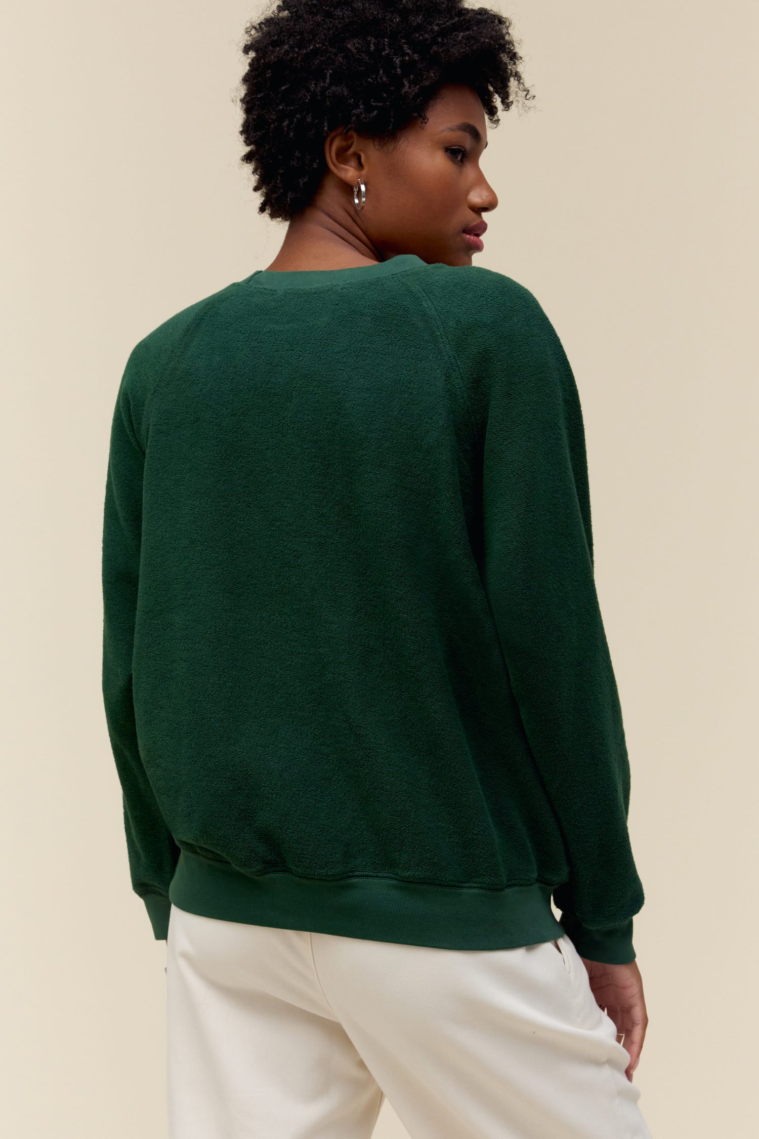 Model wearing a Sublime graphic sweatshirt in vintage green with a reverse fleece construction