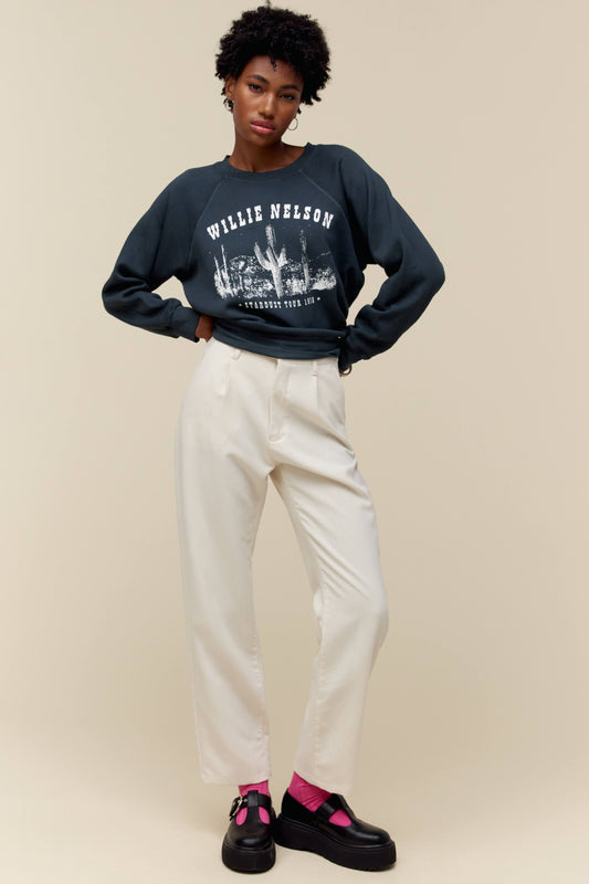 A model featuring a vintage black long sleeve stamped with Willie Nelson in white large font.