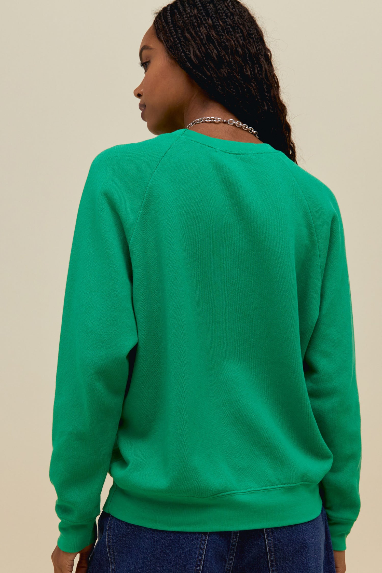 A model featuring a green long sleeve merch, stamped with "Asbury Park".