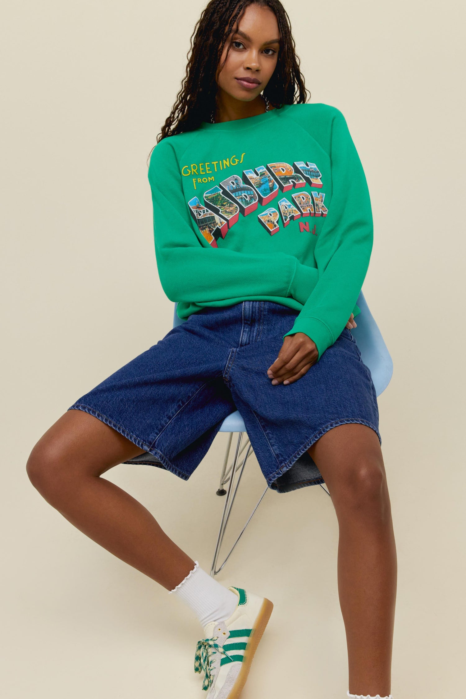 A model featuring a green long sleeve merch, stamped with "Asbury Park".