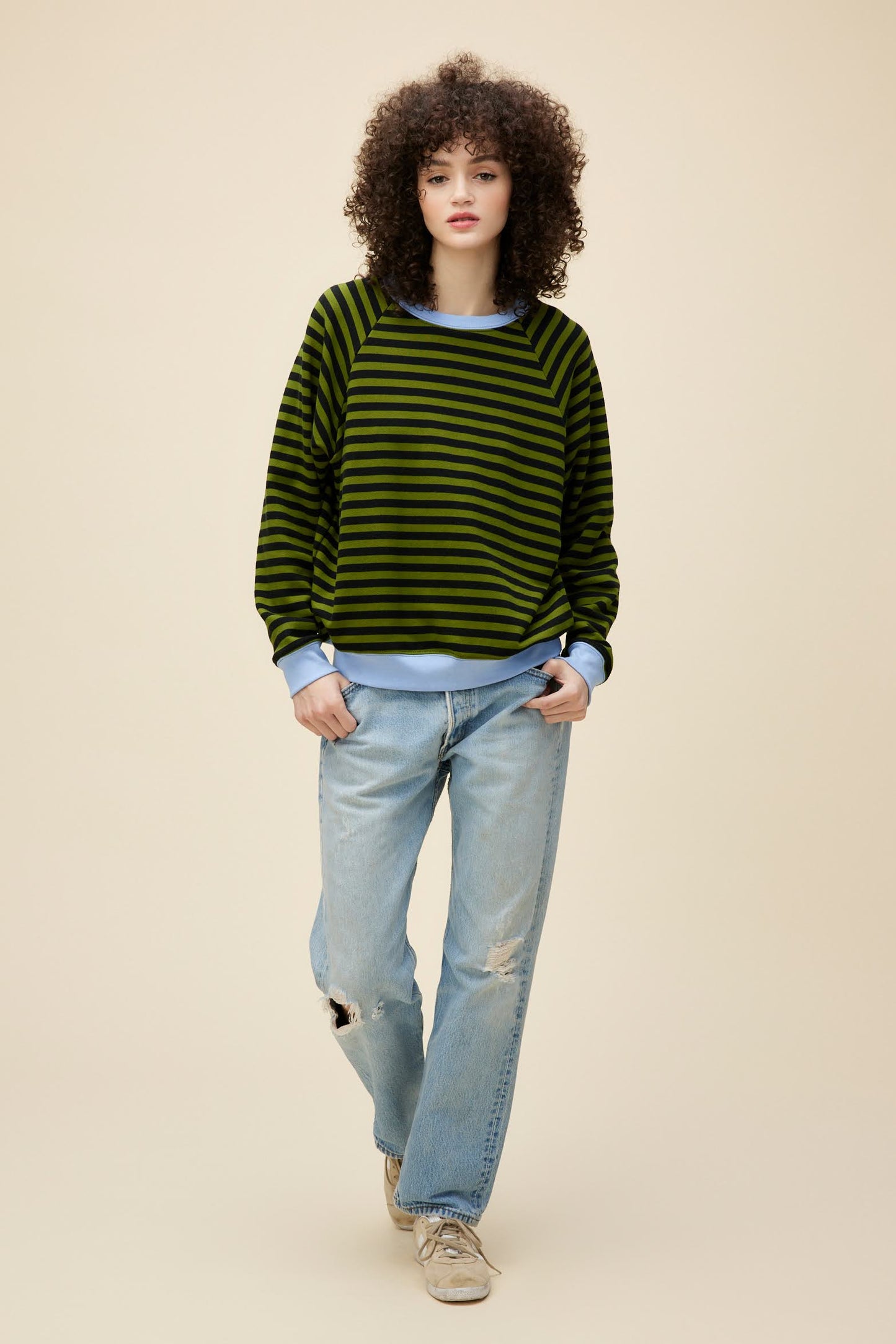 A model featuring a green combo stripe vintage sweatshirt