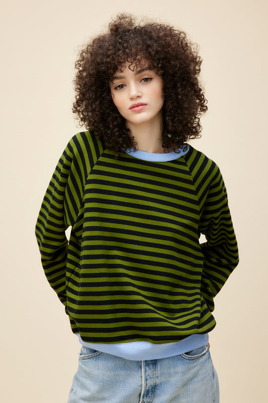 A model featuring a green combo stripe vintage sweatshirt