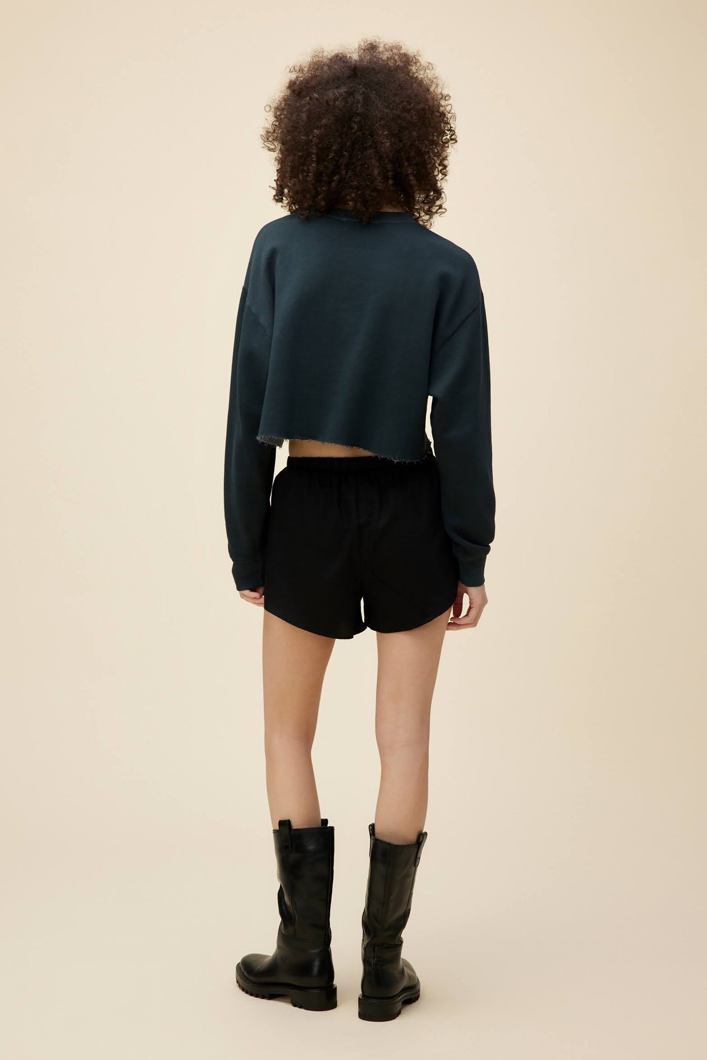 A model featuring a black solid cut off sweatshirt