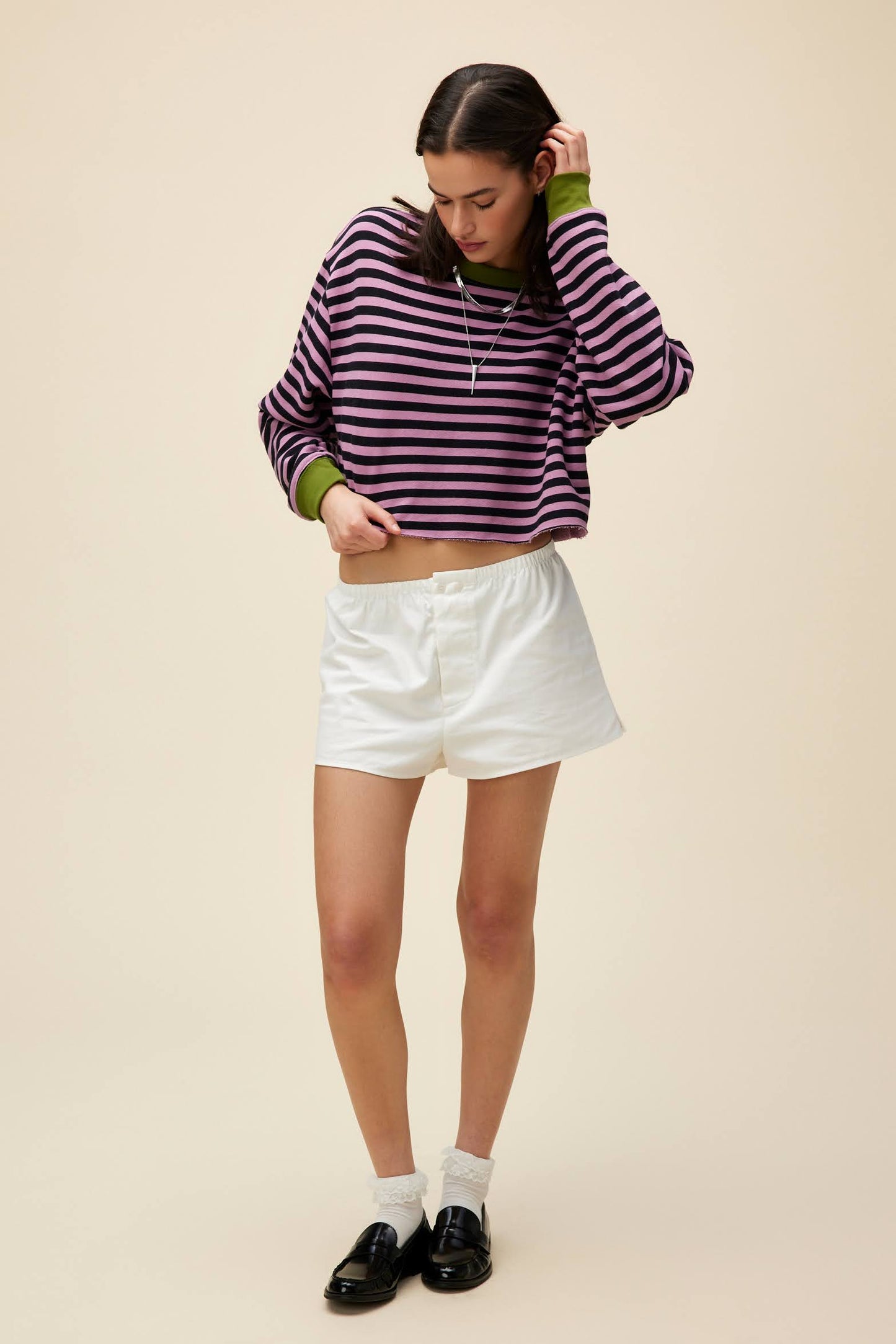 A model featuring a striped cut-off sweatshirt in lotus flower combo