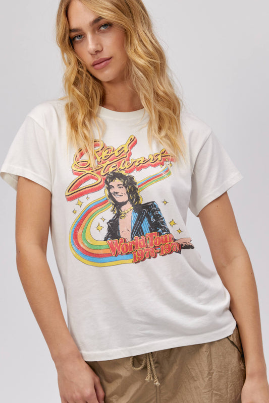 A blonde-haired model featuring a white tee stamped with 'Rod Stewart' and a portrait of the artist on top of a rainbow.