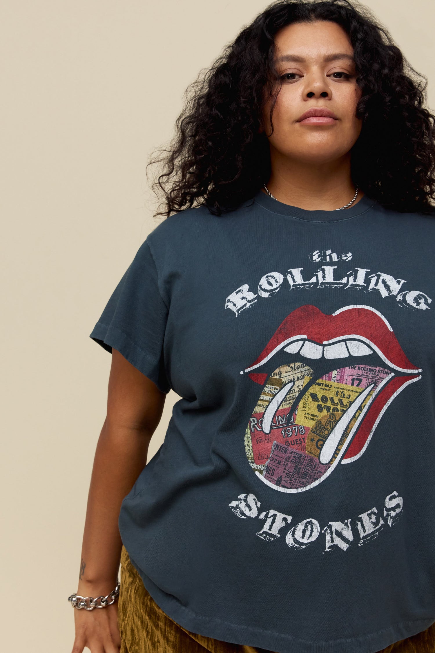A model featuring a vintage black tee stamped with the rolling stones and a tounge  graphic on the center.