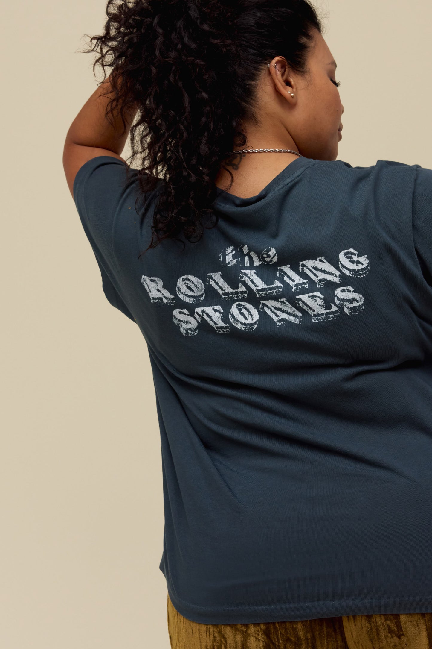 A model featuring a vintage black tee stamped with the rolling stones and a tounge  graphic on the center.
