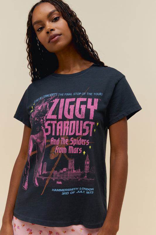 A dark-haired model wearing a black tee featuring a large font ZIGGY STARDUST AND THE SPIDERS FROM MARS and a graphic design of the artist
