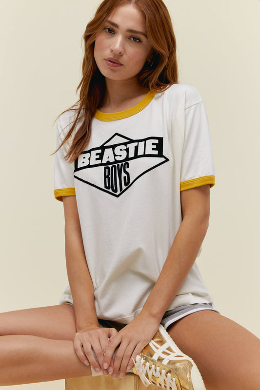 A model featuring a ringer tee with mustard-trimmed sleeves and neckline and adorned with "Beastie Boys" across the chest area