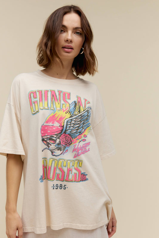 A model featuring a  white tee designed with a graphic skull with wings and a flower.
