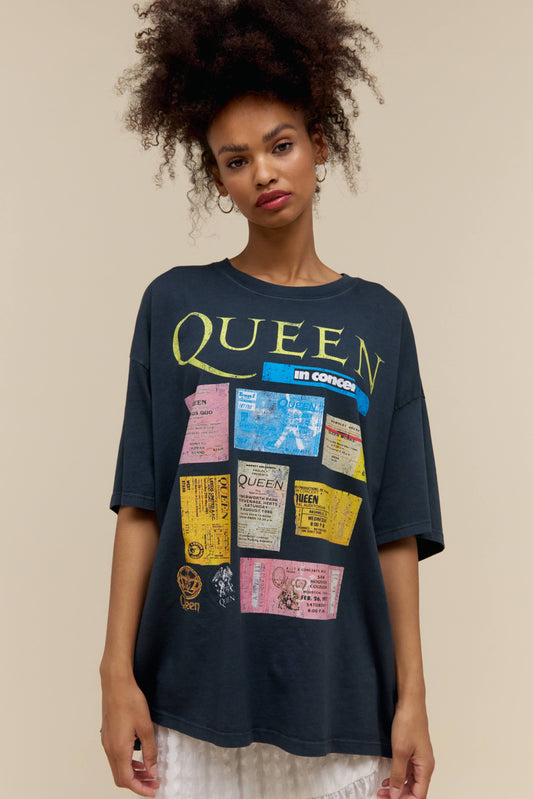 A model featuring a black os tee stamped with Queen in large font and designed with concert tickets.