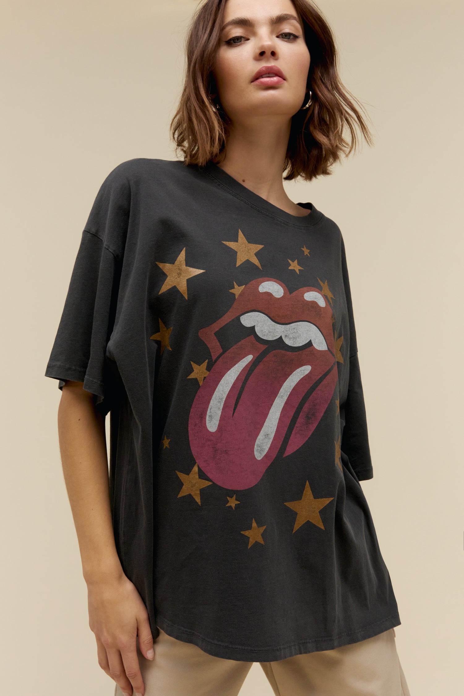 Model wearing an oversized Rolling Stones graphic tee with stars and the classic tongue logo