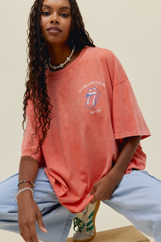 A model featuring an OS Tee stamped with 'World Tour  94-95' with a graphic tongue and tour places at the back
