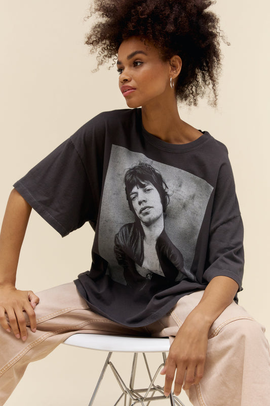 A curly-haired model wears an exaggerated oversized graphic tee of The Rolling Stones member Mick Jagger
