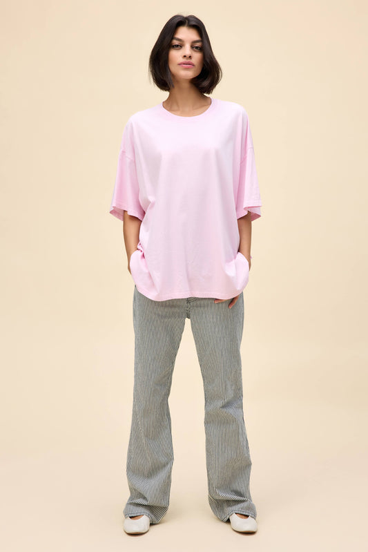 Model wearing an oversized t-shirt in light pink