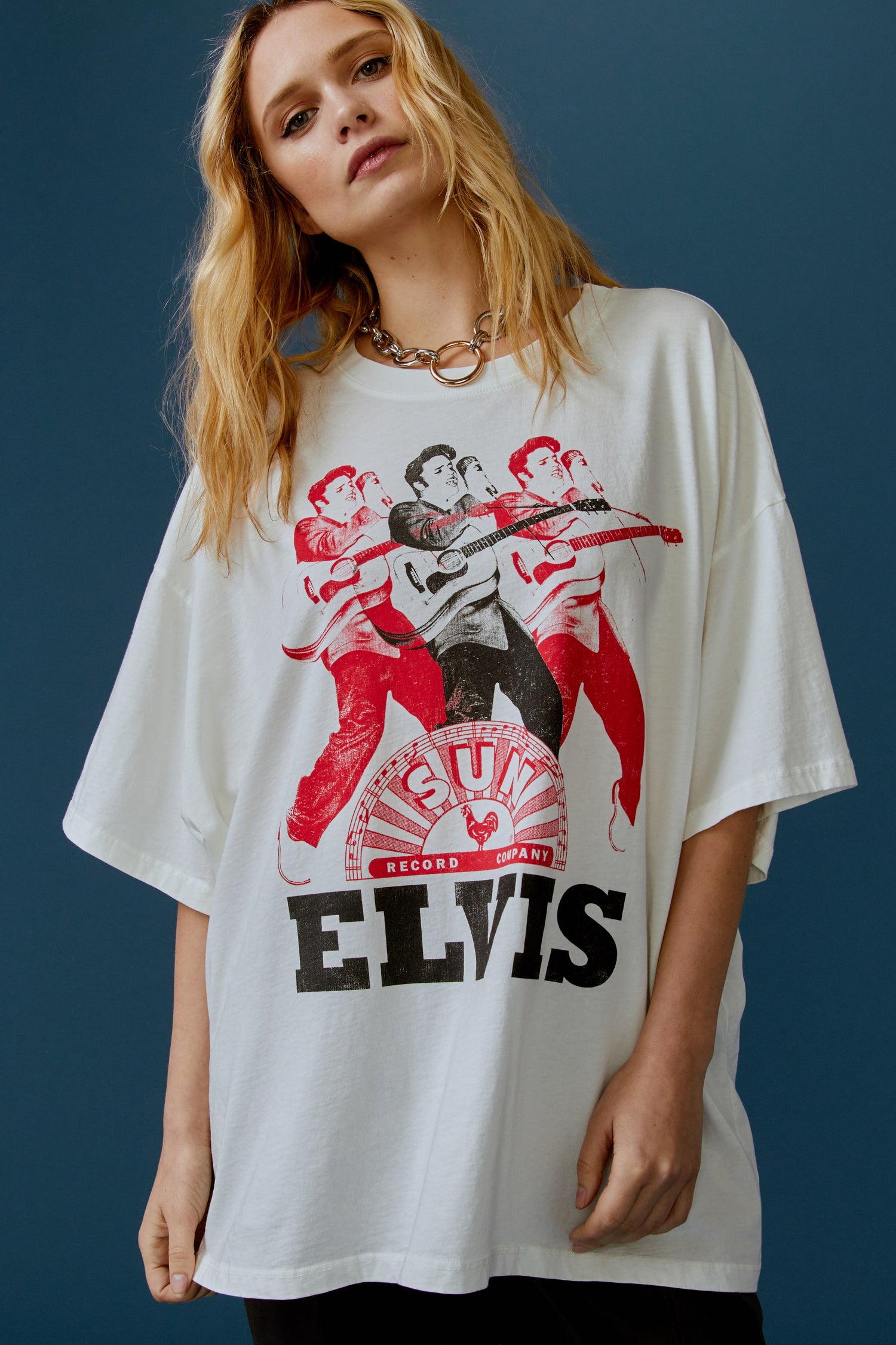 A blonde-haired model featuring a white tee stamped with the legendary artist's name and his iconic portrait in red and black inks.