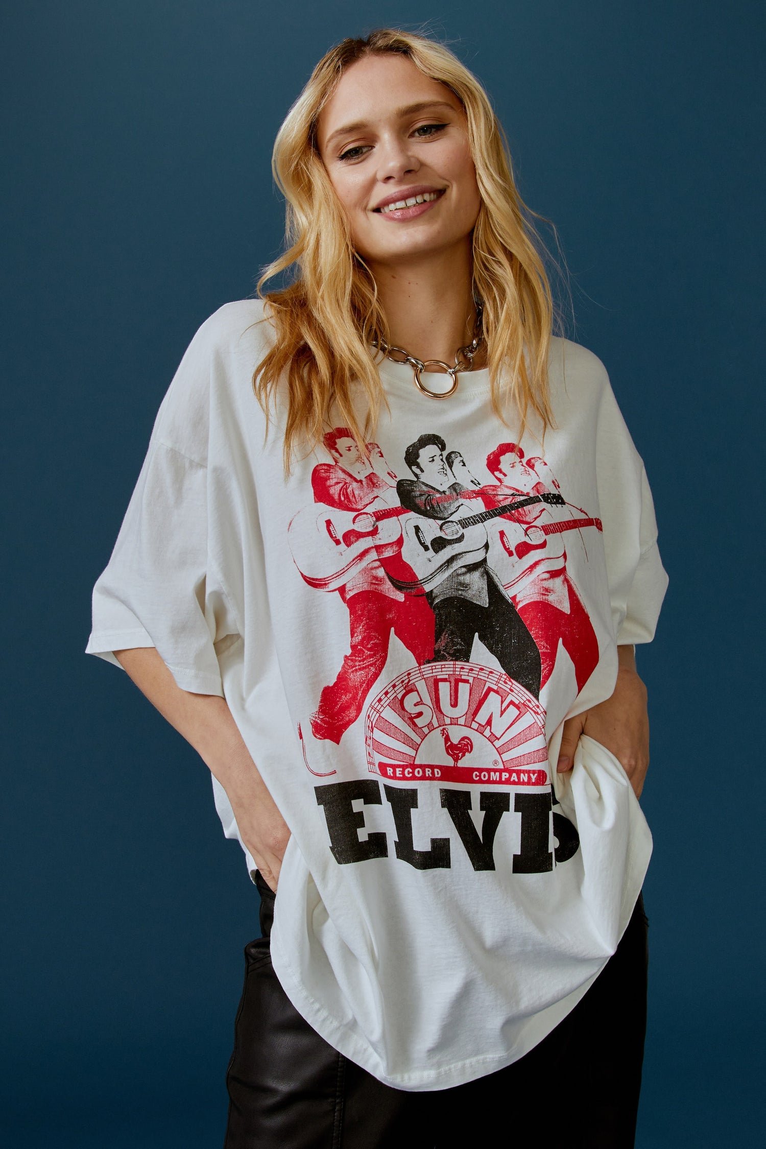 A blonde-haired model featuring a white tee stamped with the legendary artist's name and his iconic portrait in red and black inks.