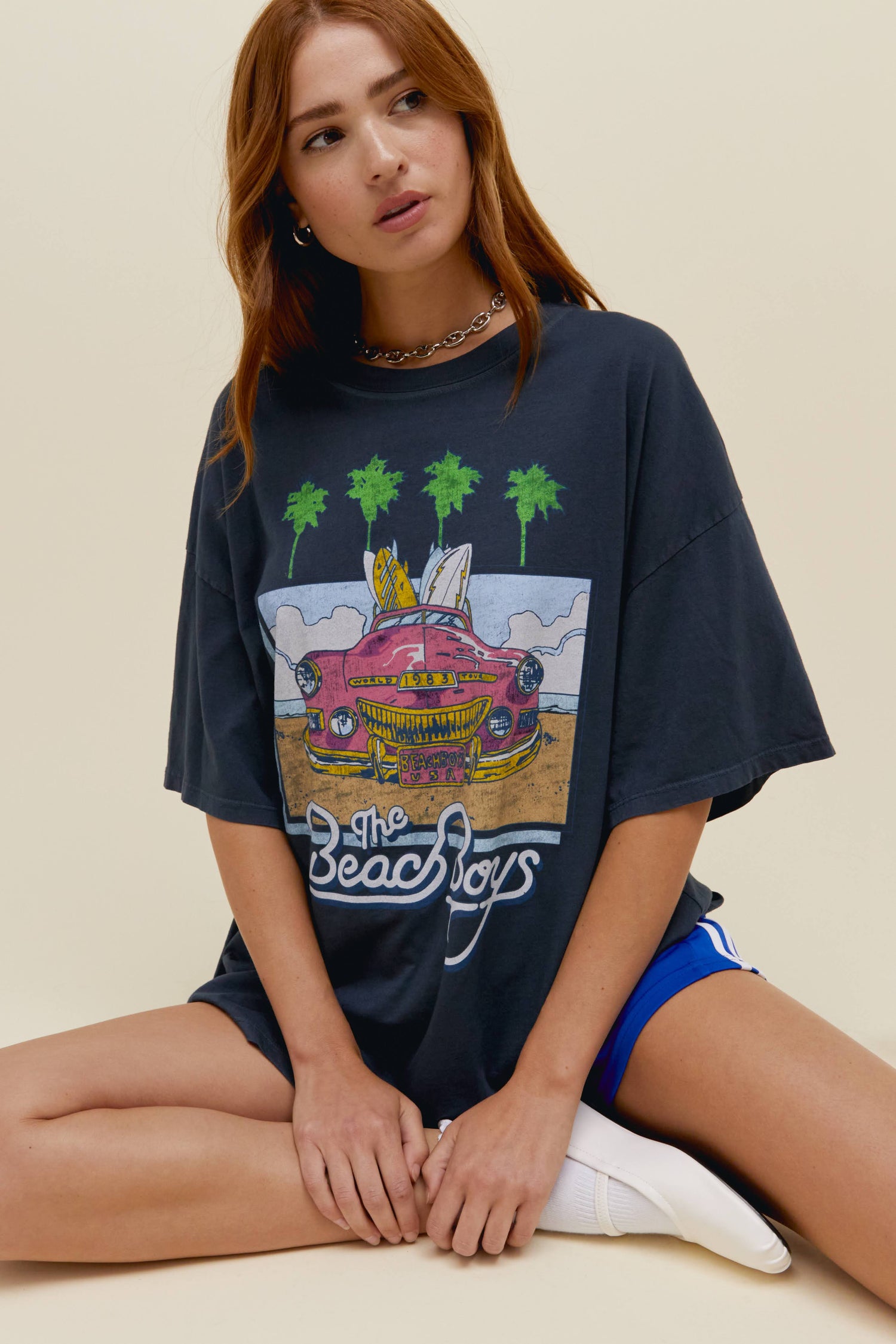 Model wearing an oversized The Beach Boys graphic tour tee in vintage black.