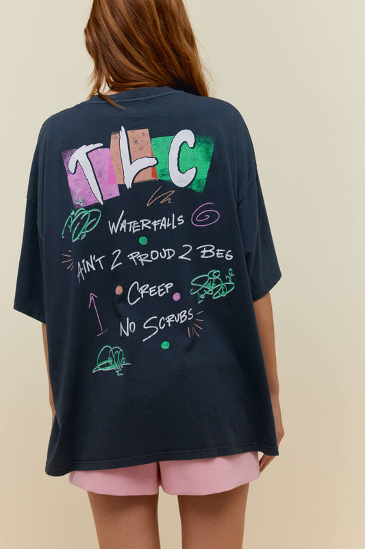 A model featuring a black solo tee stamped with 'TLC' and a graphic photo of the band