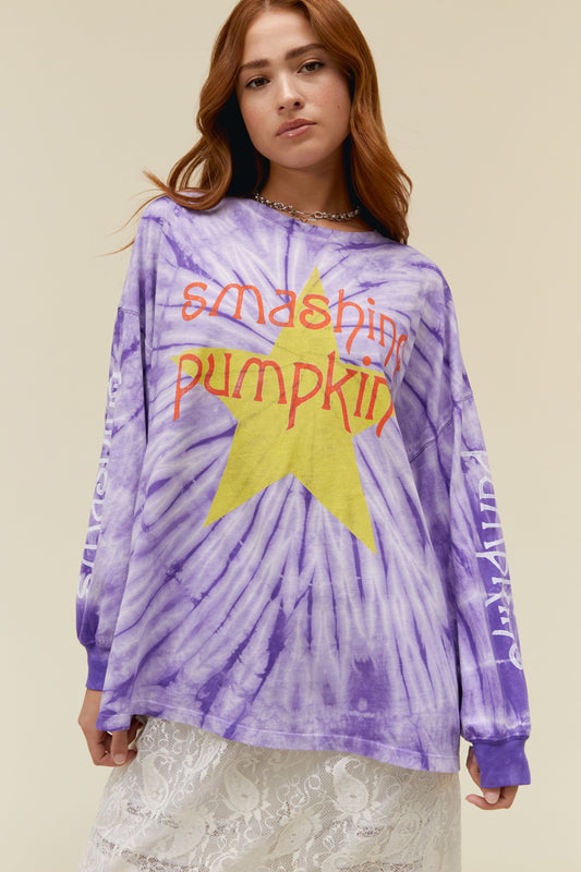 A  model wearing a purple tie dye long sleeves featuring a large "SMASHING PUMPKIN" with a graphic star on it. The words "Smashing" and "Pumpkin" are also written on each of the sleeves. 