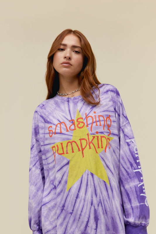A  model wearing a purple tie dye long sleeves featuring a large "SMASHING PUMPKIN" with a graphic star on it. The words "Smashing" and "Pumpkin" are also written on each of the sleeves. 