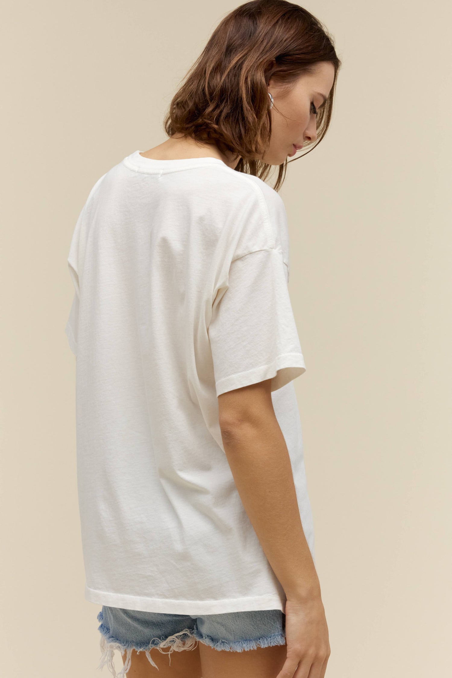 A model featuring a white tee with a graphic  design and stamped with 'Beastie Boys'.