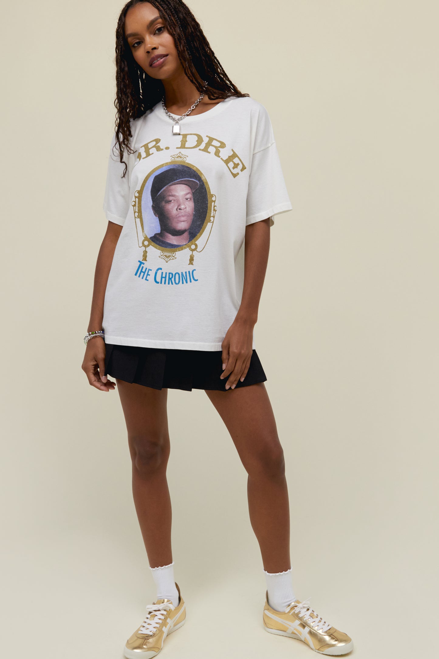 A dark-haired model featuring a white tee designed with the album's cover artwork accented in gold ink and featuring a portrait of the legend.