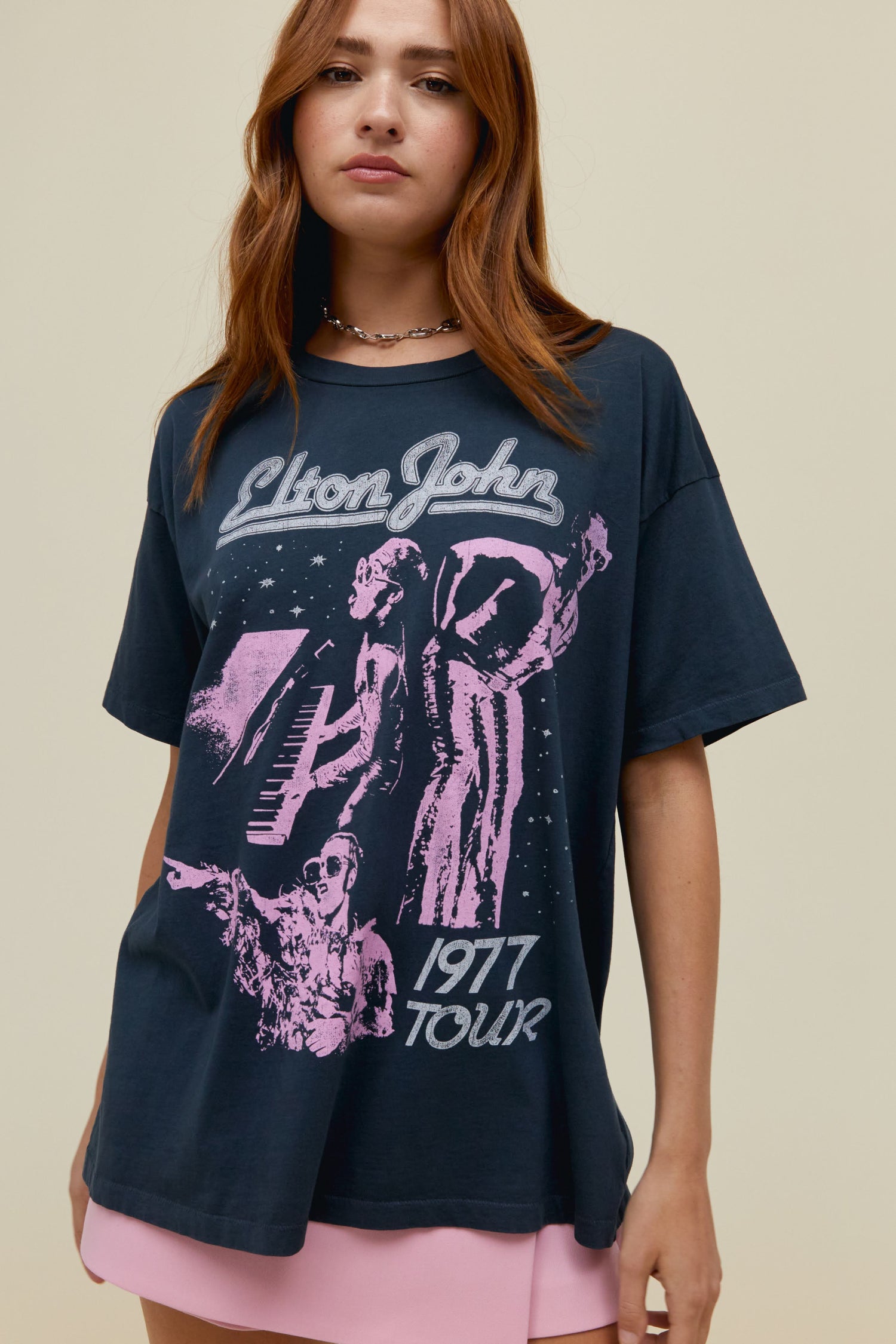 Model wearing a vintage black Elton John 1997 Tour graphic tee with contrast pink artwork.