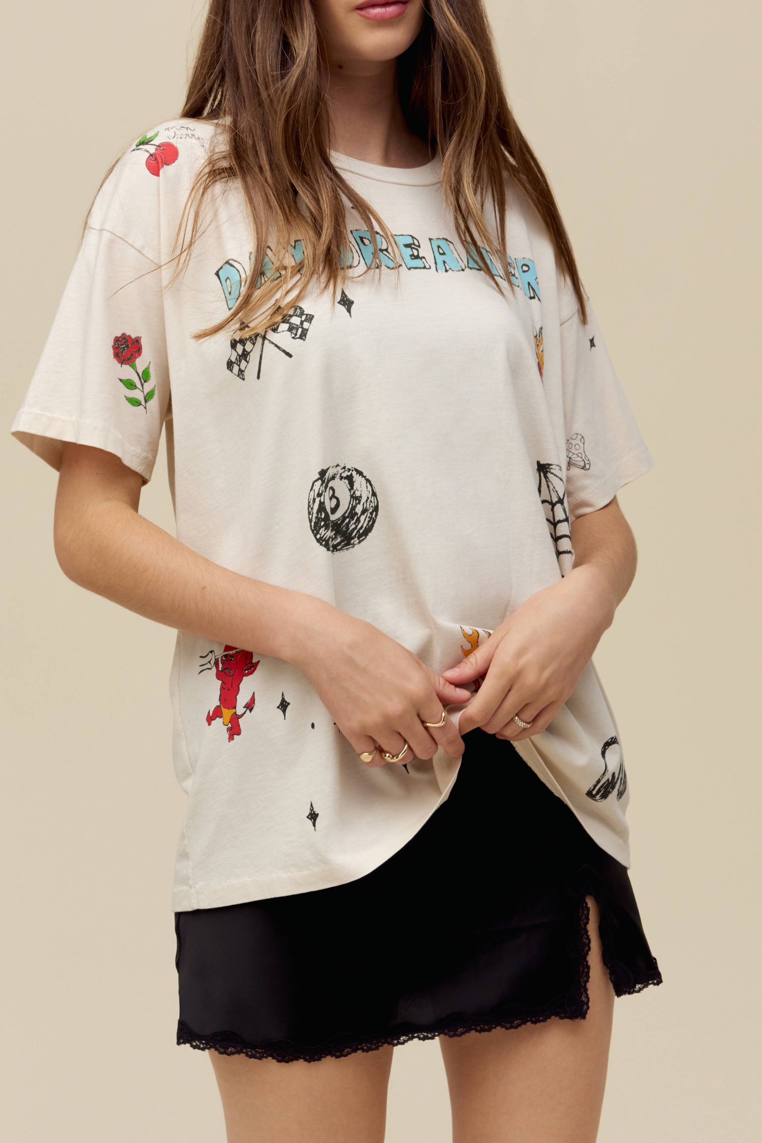 A model featuring a white tee stamped with daydreamer and designed with hand-drawn symbols.