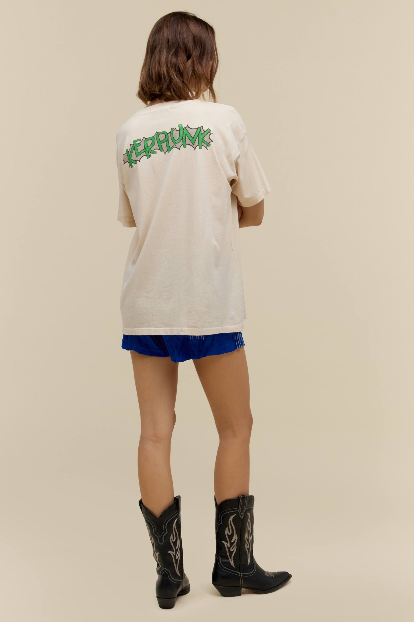 A model featuring a white tee stamped with 'Green Day' and a graphic flower pot in the middle.