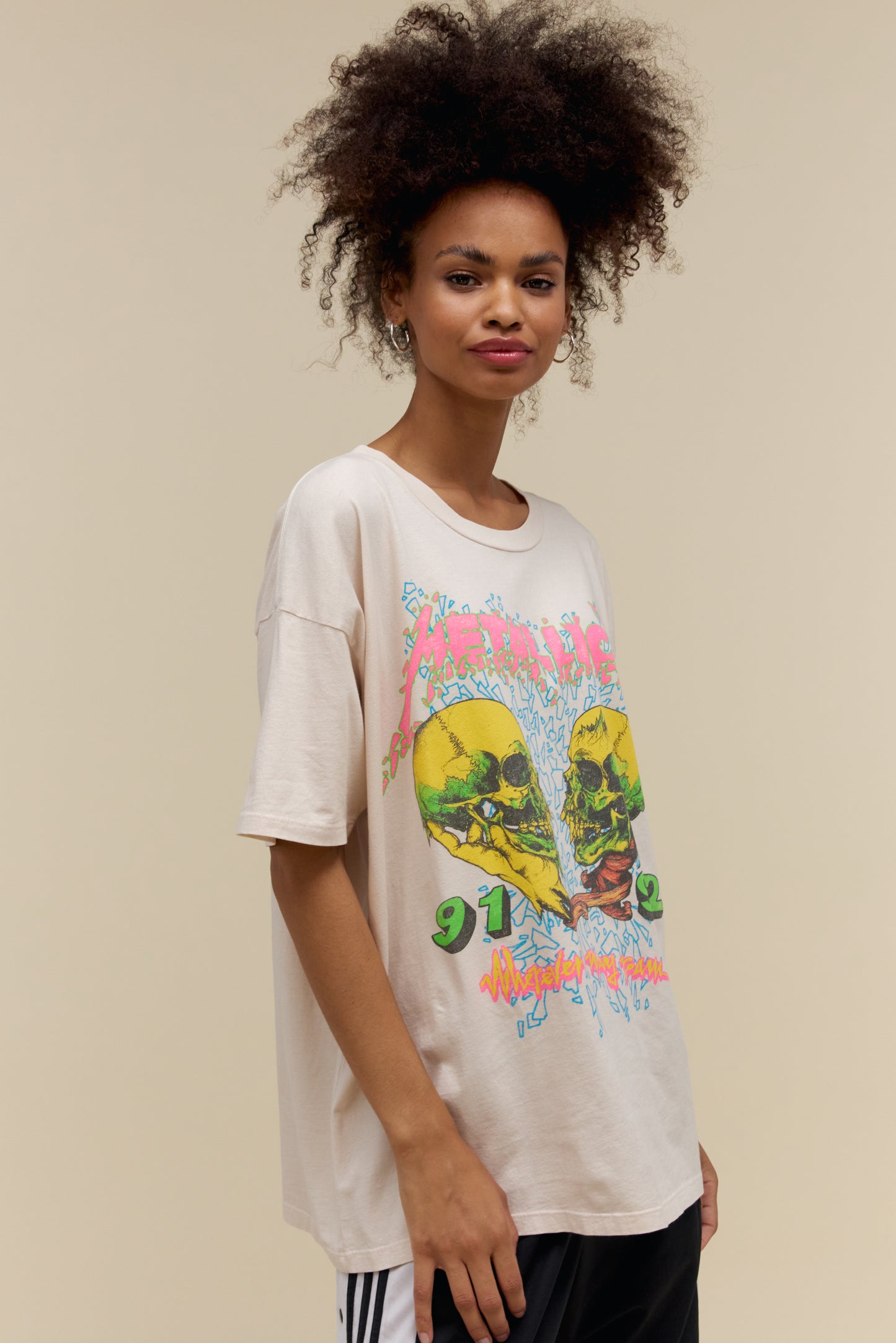 Model wearing an oversized Metallica 'Wherever I May Roam' graphic tee in dirty white with skull artwork