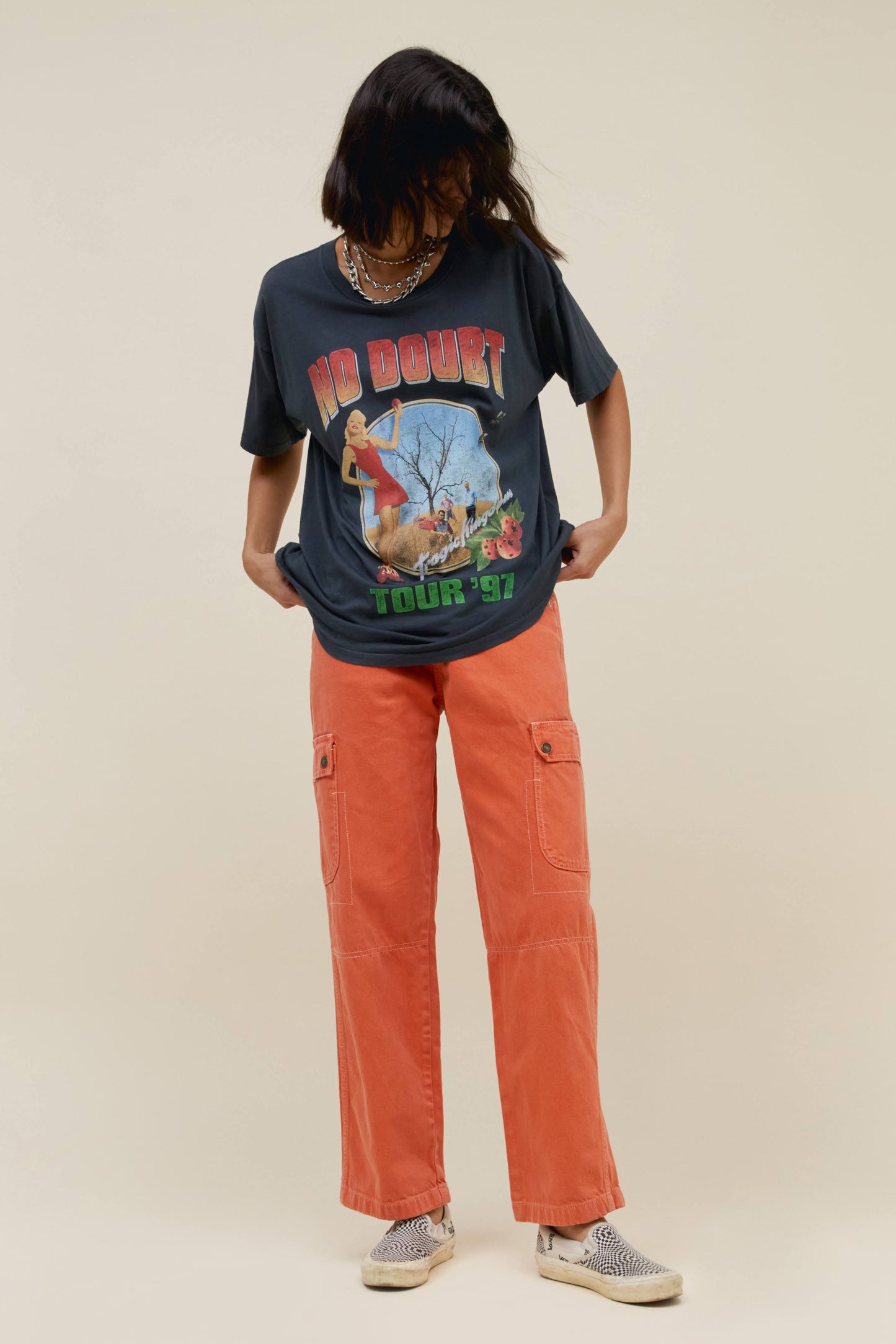 Model with bob wearing No Doubt black graphic tee and orange pants.
