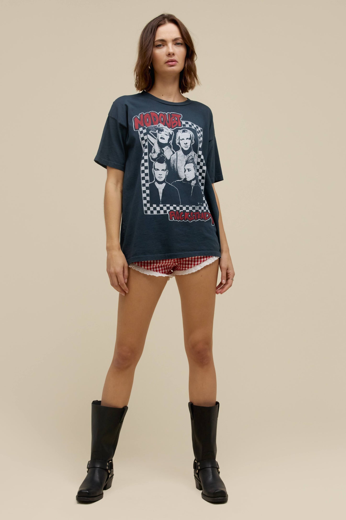 A model featuring a black merch tee design with a group photo of the No Doubt band.