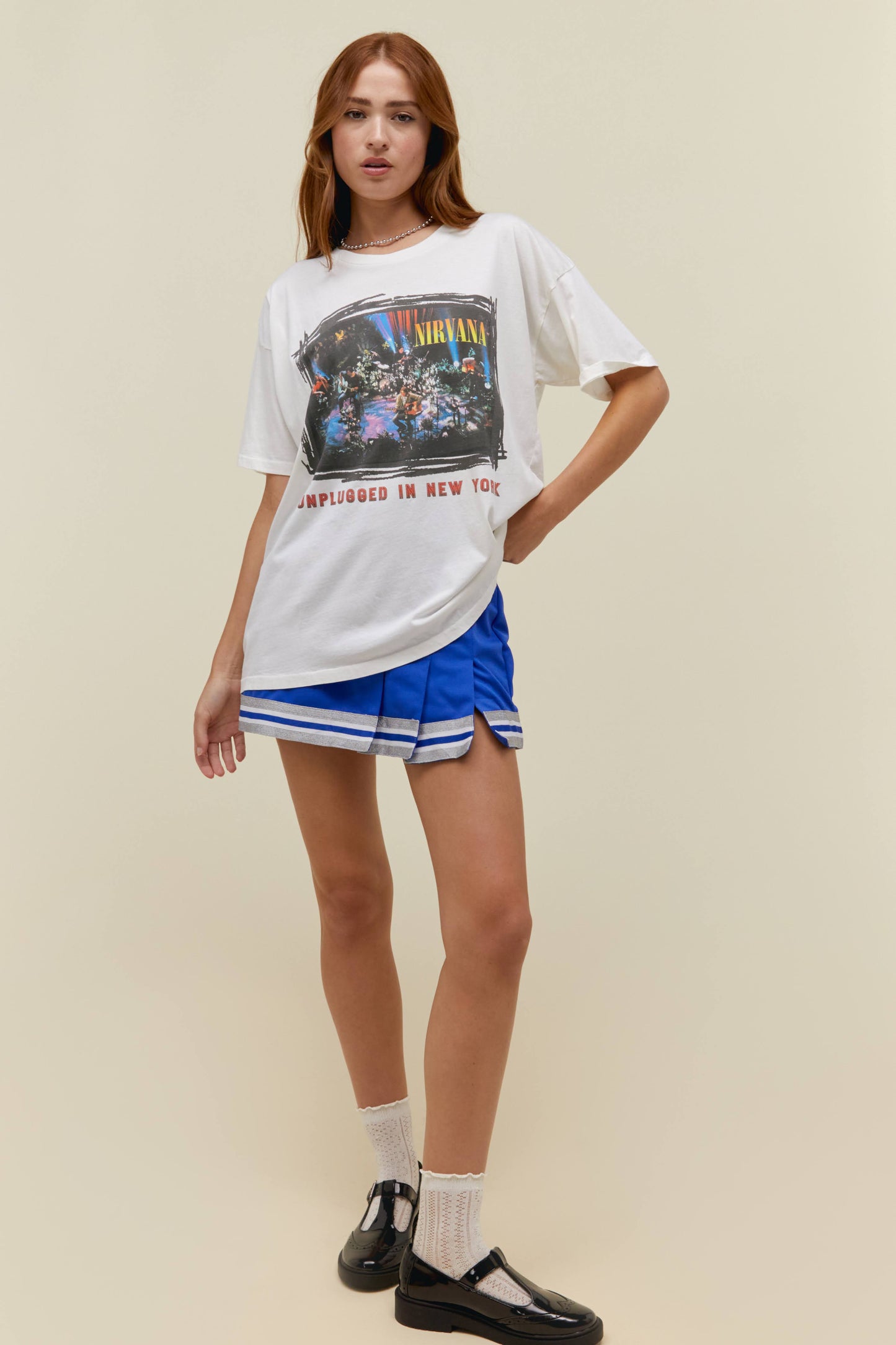 A model featuring a Nirvana unplugged merch tee in vintage white with an oversized fit.